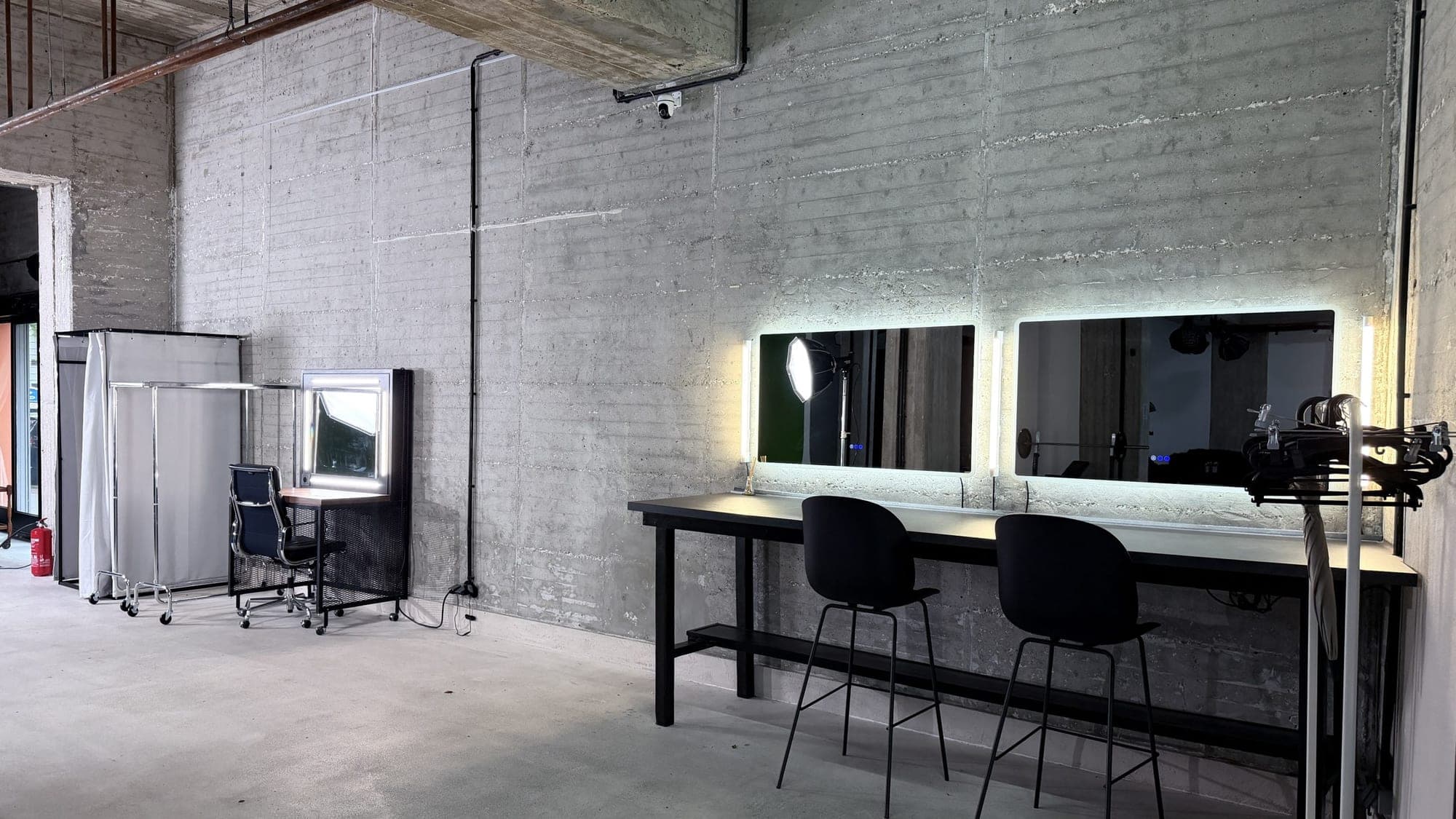 Make-up-Bereich mit beleuchteten Spiegeln und Umkleide im qre8.studio